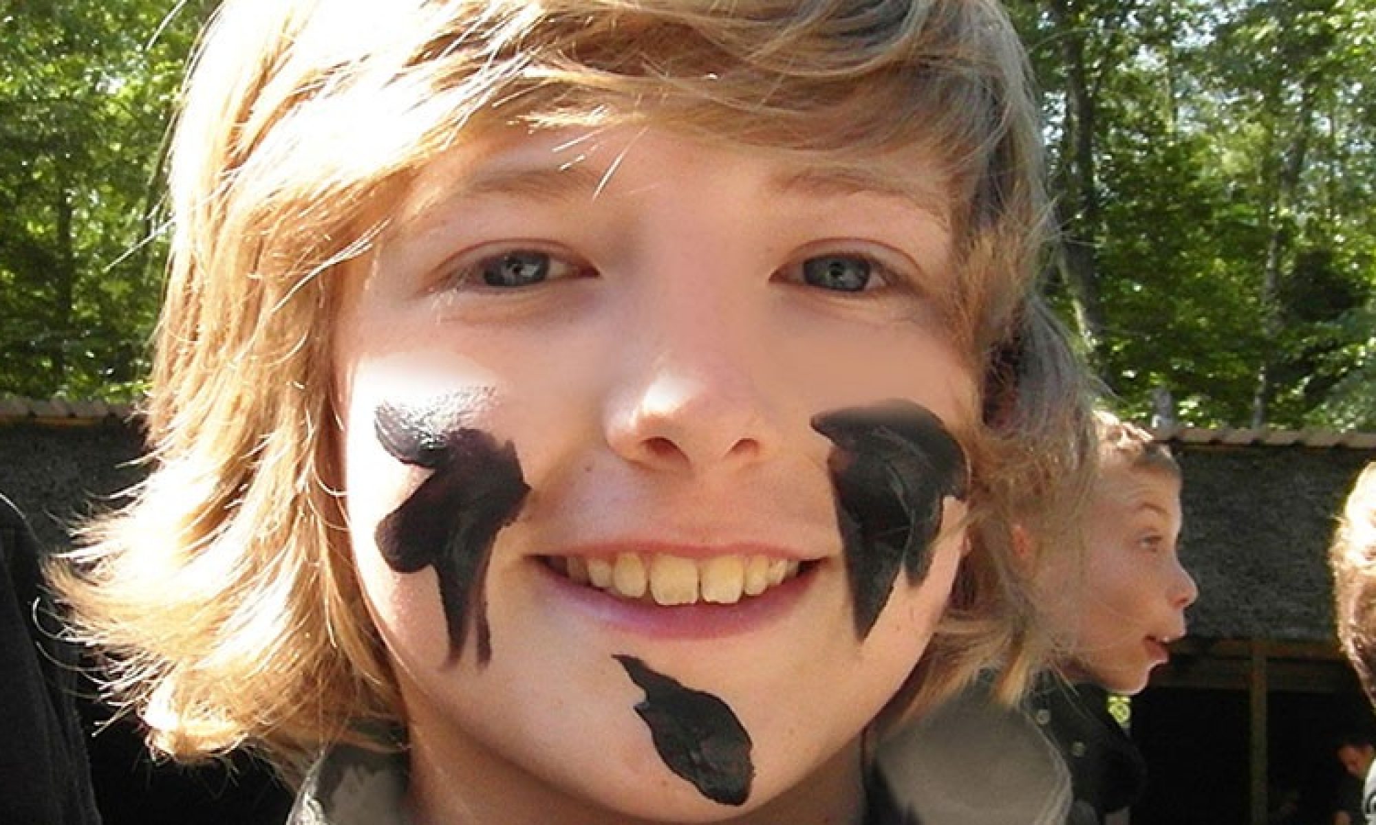 A young paintball player in protective goggles